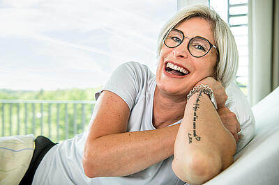 Lachende Patientin in einem Pflegebett