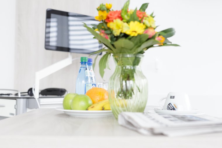 Patienten Einzelzimmer Nahaufnahme Tisch mit Blumen und Obst - Benedictus Krankenhaus Feldafing